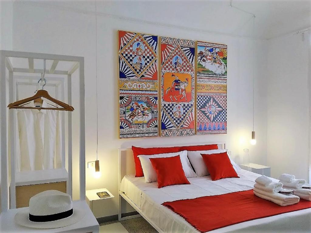パレルモにあるCOLORI di PALERMOのベッドルーム1室(赤い枕と絵画付)