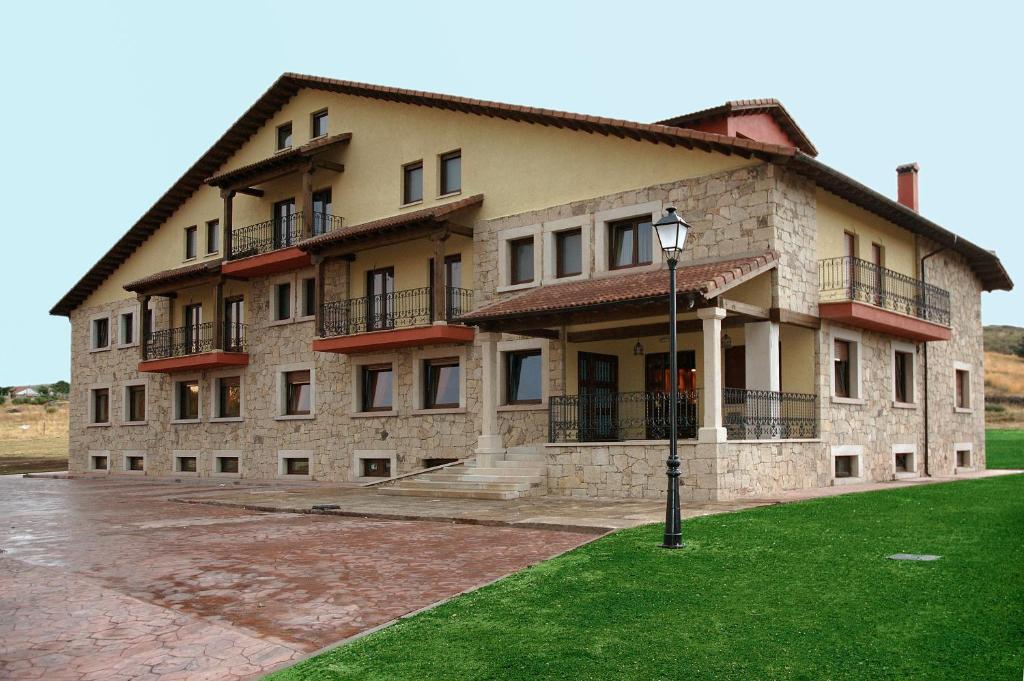 un gran edificio de piedra con una luz de la calle delante de él en Hotel Garabatos en Navarredonda de Gredos