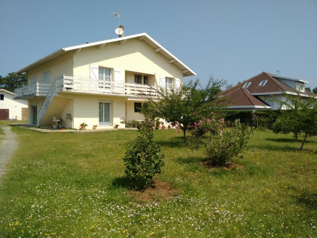 a white house with a balcony on top of a yard at Côte Landaise in Tarnos