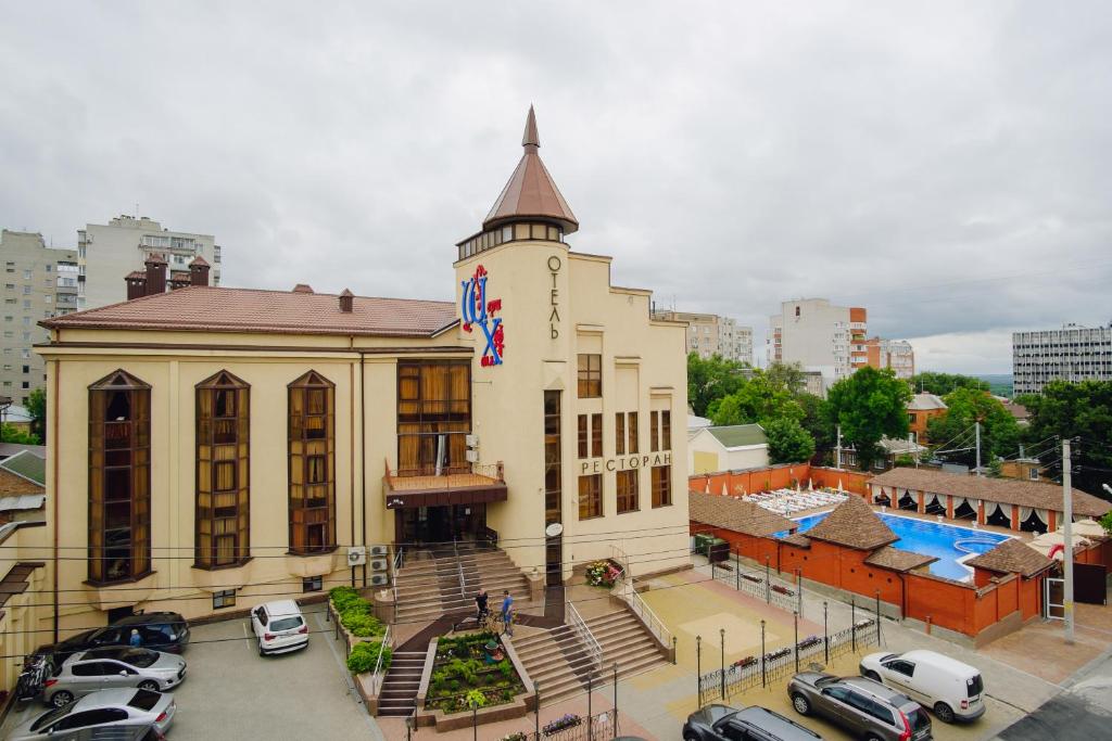 a building with cars parked in a parking lot at Shery Holl in Rostov on Don