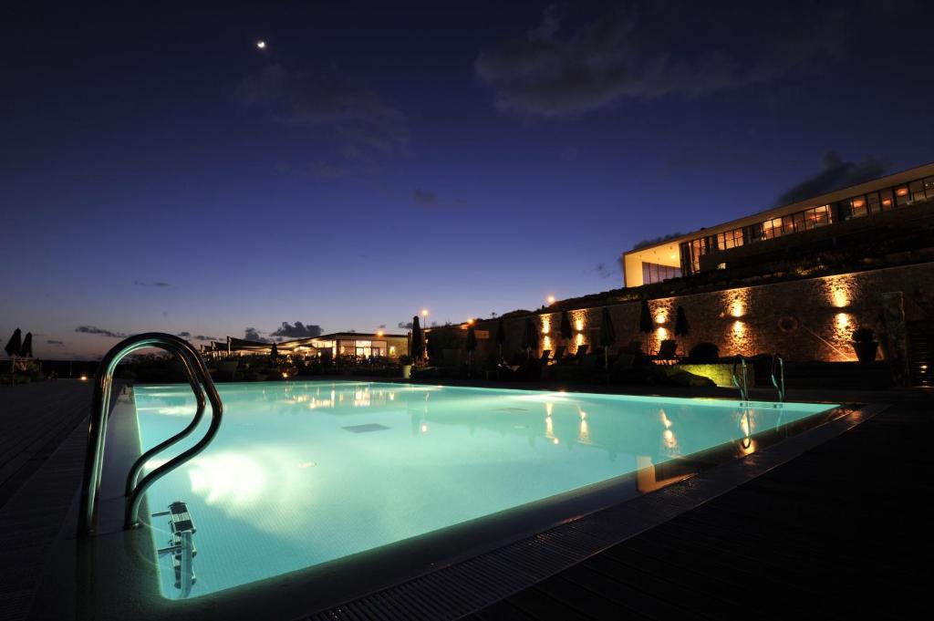 a large swimming pool at night with a building at Martinhal Sagres Beach Family Resort Hotel in Sagres