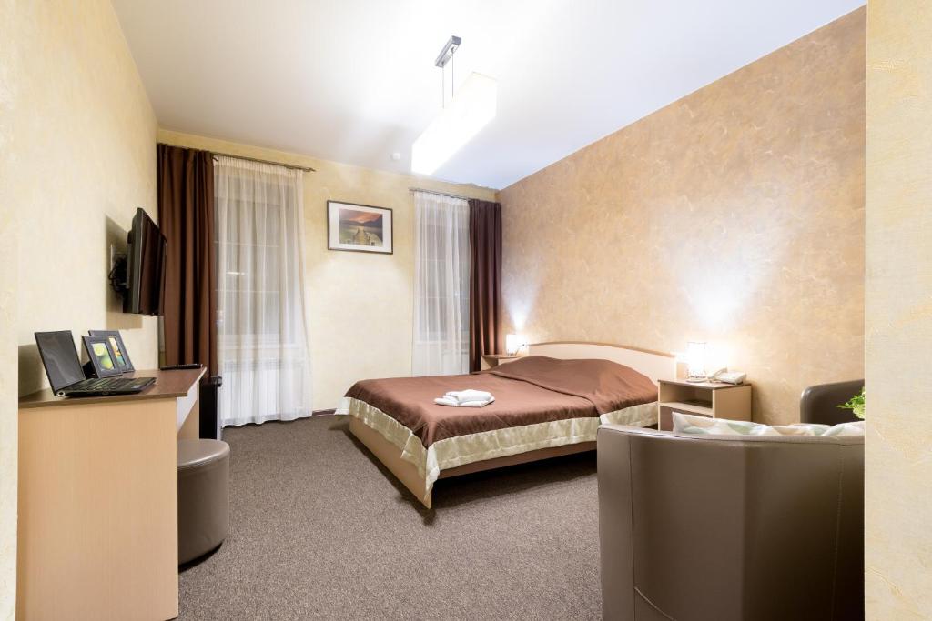 a hotel room with a bed and a desk at Shale on Komsomolsky in Novosibirsk