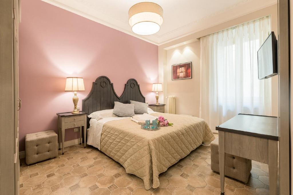 a bedroom with a large bed and a television at Altarocca Embassy Rome in Rome