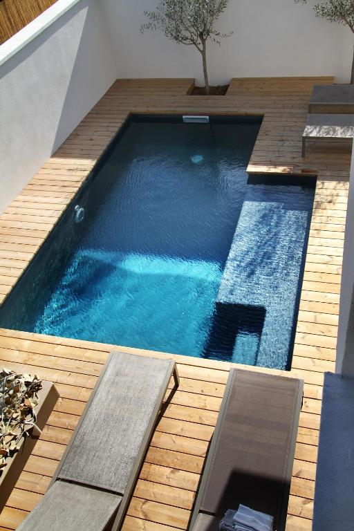 une grande piscine sur une terrasse en bois dans l'établissement Les Loges En Provence 