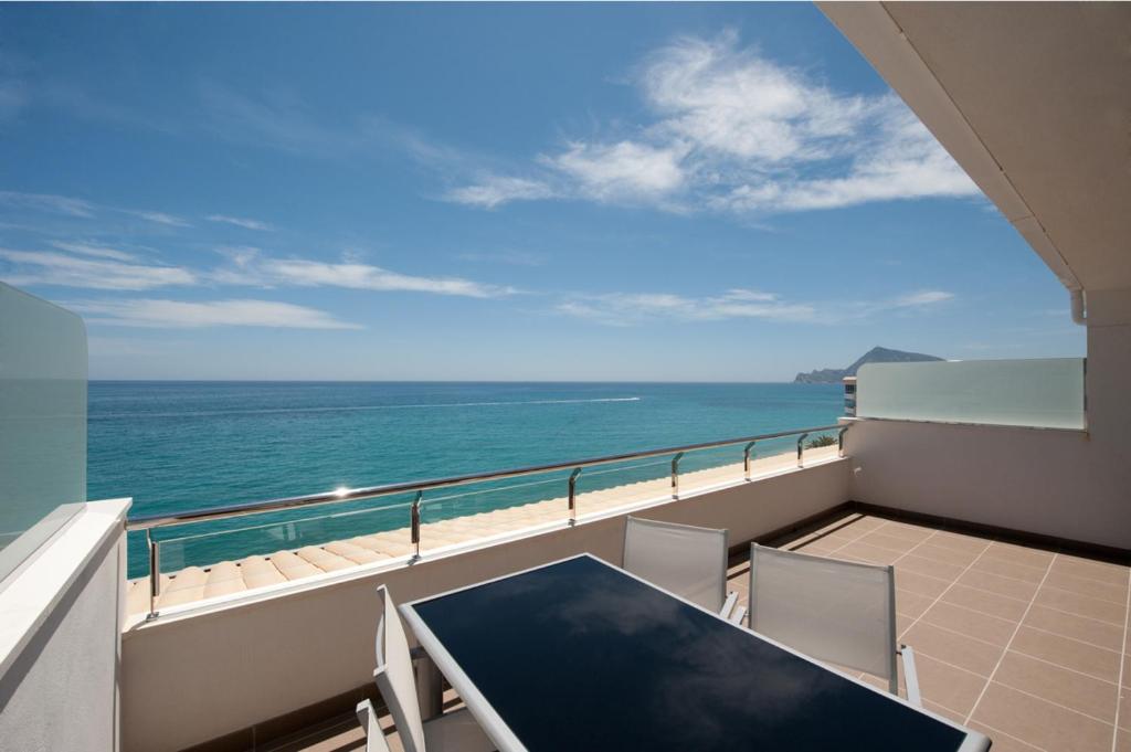 a balcony with a table and chairs and the ocean at Apartamentos Calpestabili in Altea