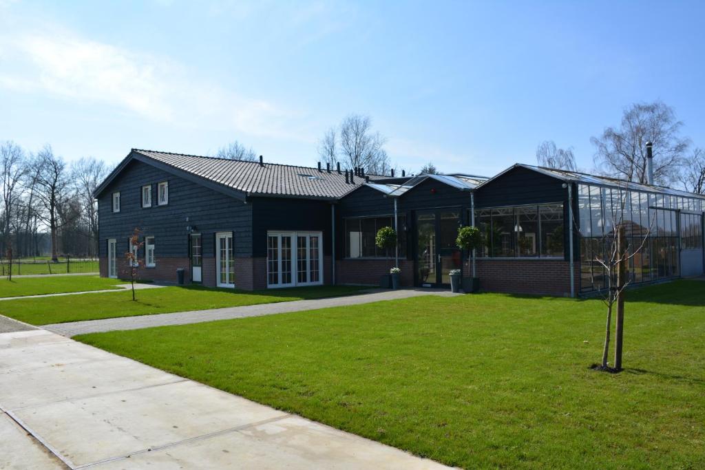 a black house with a green lawn in front of it at 2 persoons appartement in Heeze