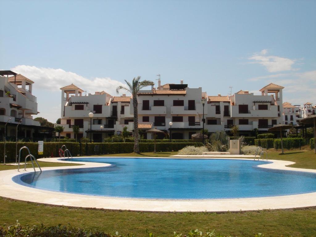 una gran piscina azul con apartamentos en el fondo en Apartamento MPS Jardines de Nuevo Vera, en Vera