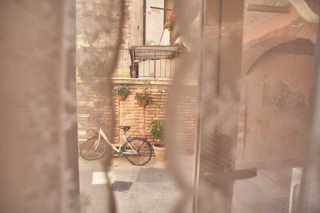 una bicicletta parcheggiata in un vicolo con un edificio di Abbraccio di Romeo a Verona