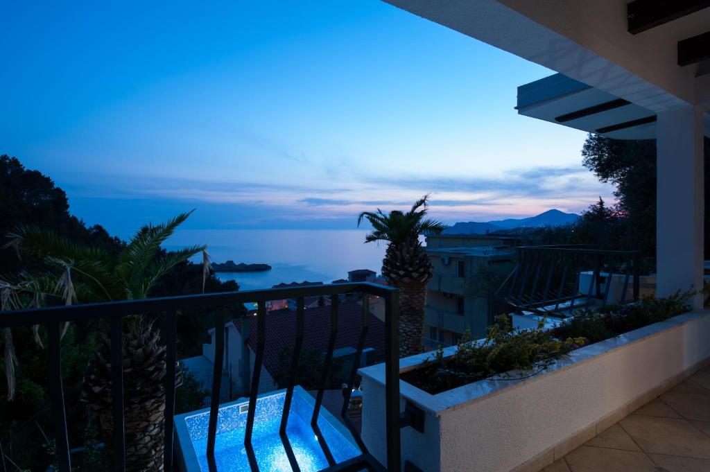 a balcony with a view of the ocean at night at Villa Mia in Sveti Stefan