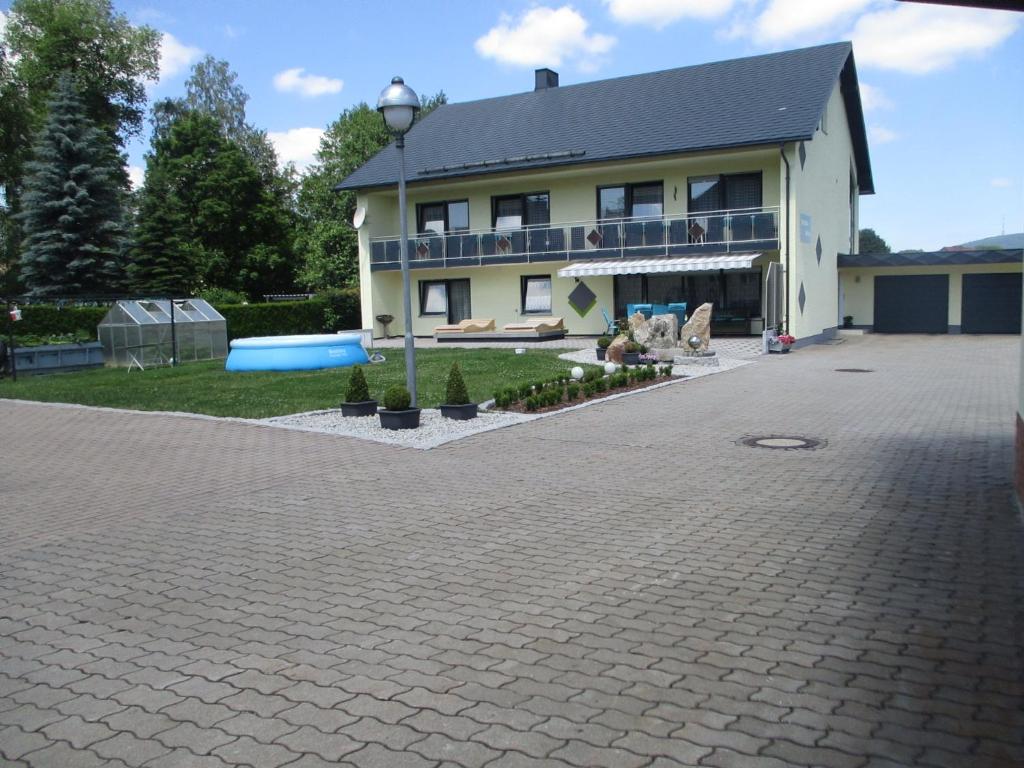 una casa grande con una gran entrada de entrada frente a ella en Pension Erika, en Mehlmeisel