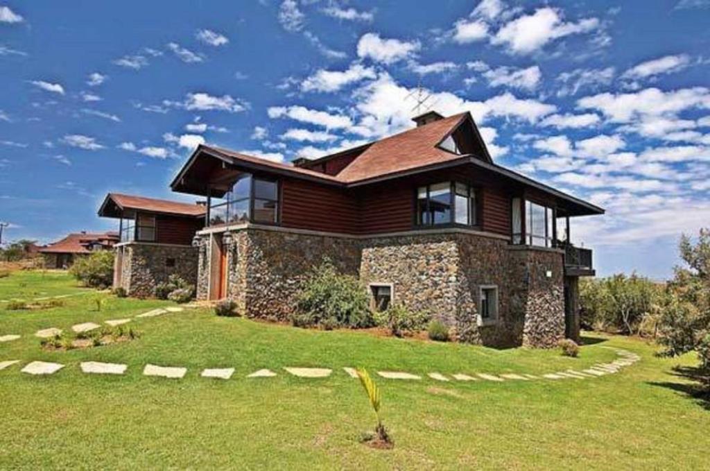 una casa grande con un gran patio delante en The Great Rift Valley Lodge & Golf Resort, en Naivasha