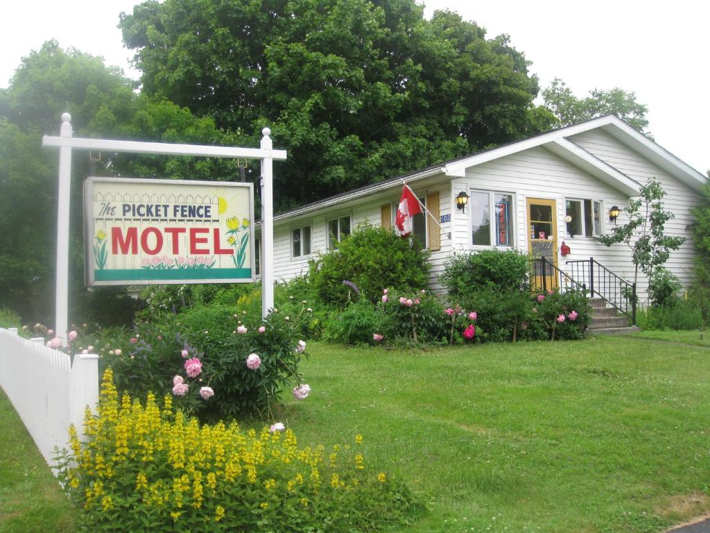 a house with a sign that reads the perfect house motel at Picket Fence Motel in Saint Andrews