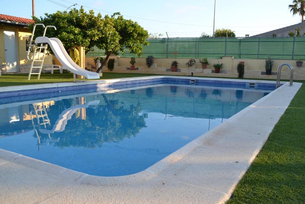 a swimming pool with a slide in a yard at Posada Chloe Santiago in Santiago de la Ribera