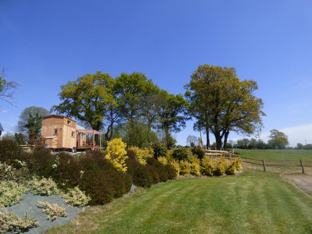 una casa in mezzo a un campo con cespugli di le Vallon des 5 Roses a Saint-Hilaire-du-Maine