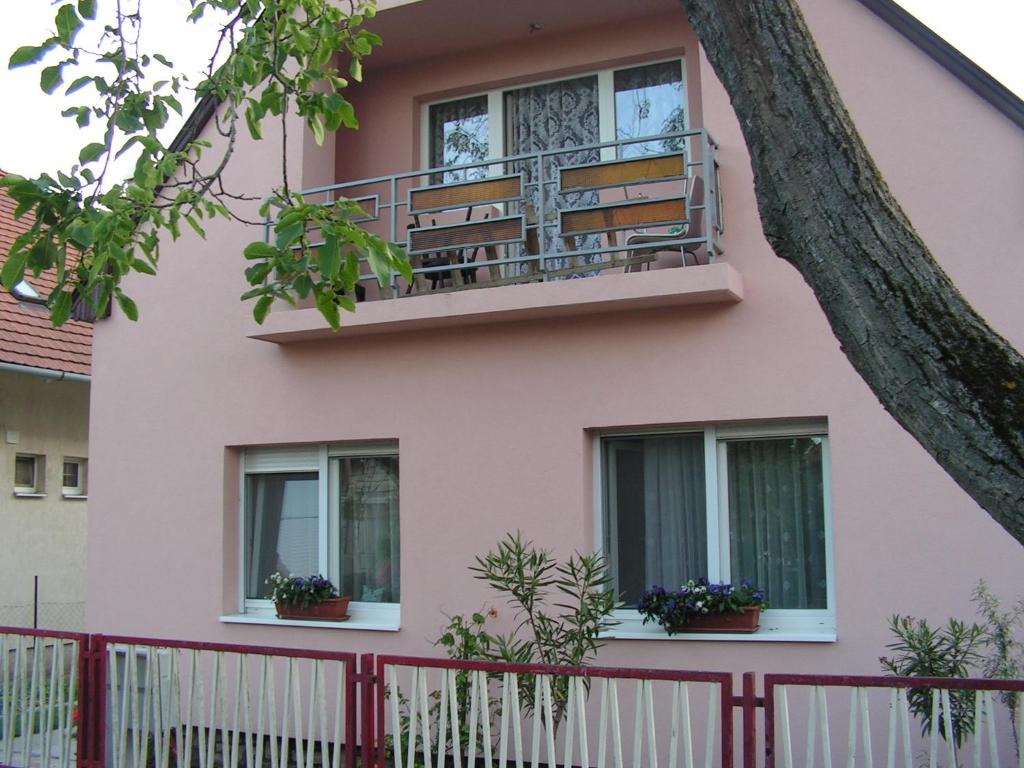 シオーフォクにあるLehoczki Apartmanの窓と木のあるピンクの家