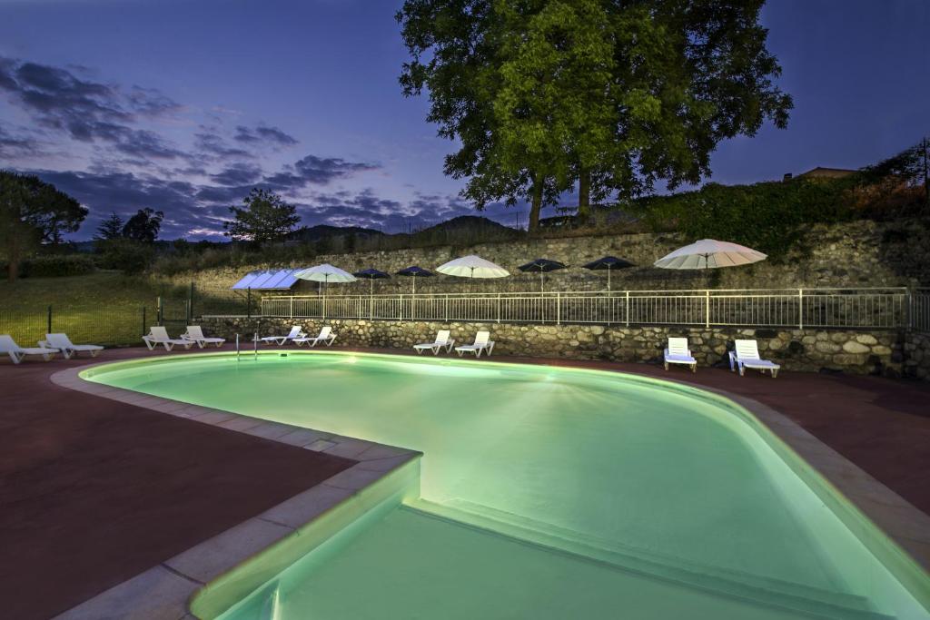 a swimming pool with chairs and umbrellas at Le Moulin de Sournia in Sournia