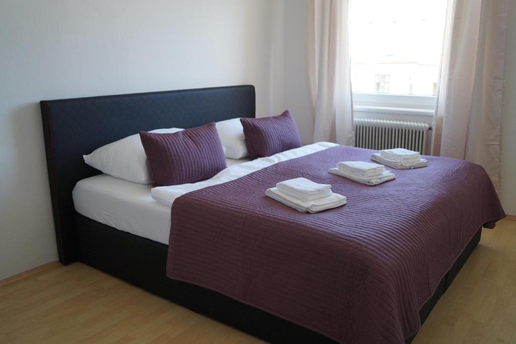 a bed with two folded towels on top of it at Herbststrasse Apartment in Vienna