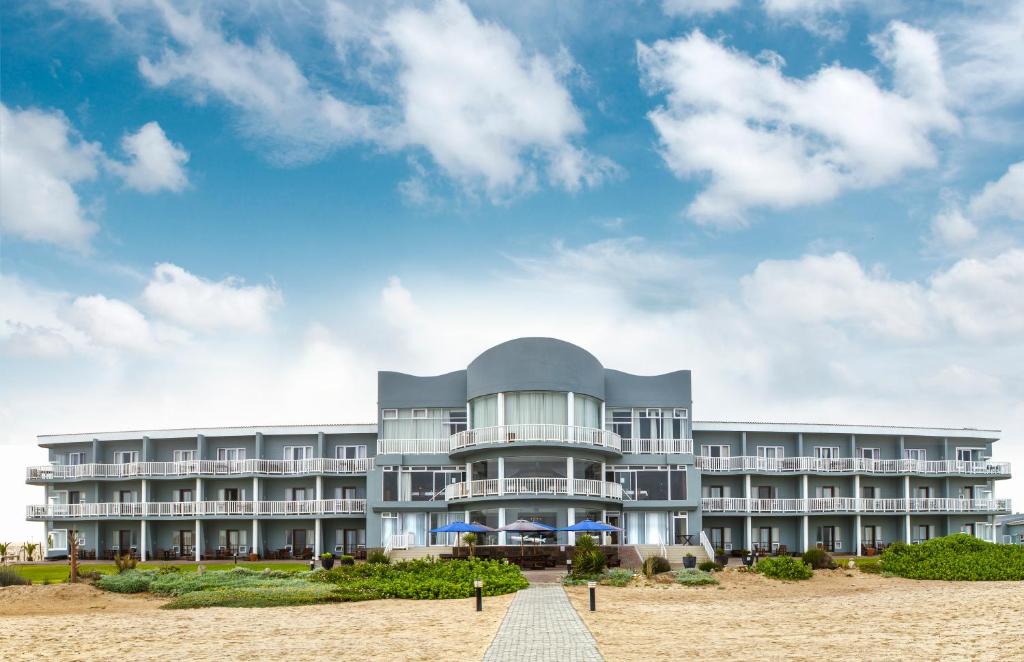 a building on the beach with a blue sky at SeaSide Hotel & Spa in Swakopmund