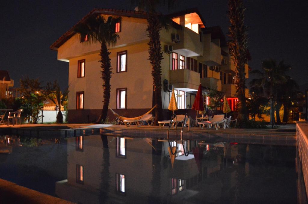 una casa y una piscina por la noche en Erasmus Apart Hotel en Dalyan