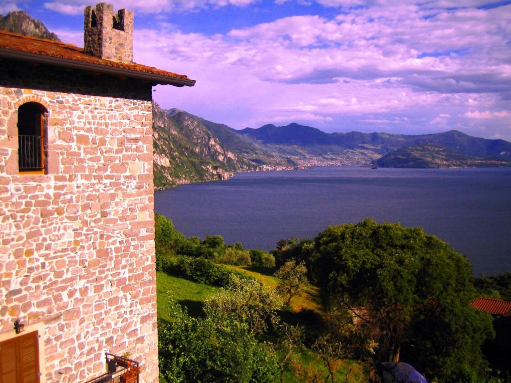 a building with a view of a body of water at Castello di Zorzino Iseo lake in Riva di Solto