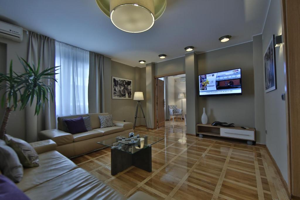 a living room with a couch and a tv at Aber Apartment in Belgrade
