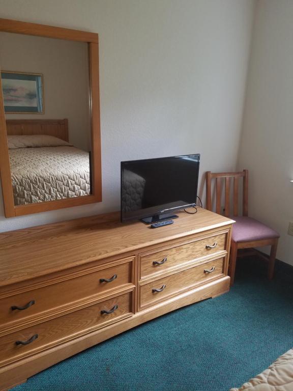 a bedroom with a television on a dresser with a mirror at Affordable Suites Gastonia in Gastonia