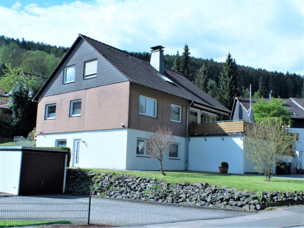 a large house with a stone retaining wall at Ferienwohnung Seibt in Plettenberg