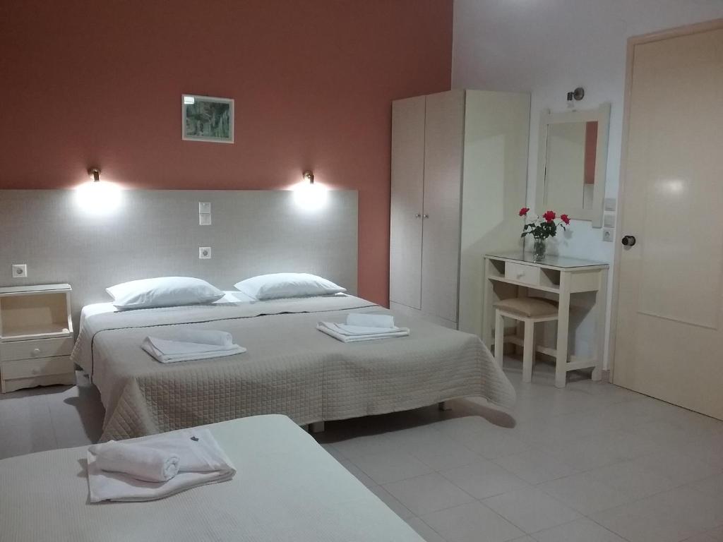 a bedroom with two beds and a table and a sink at Ilona Apartments Chania in Kato Daratso