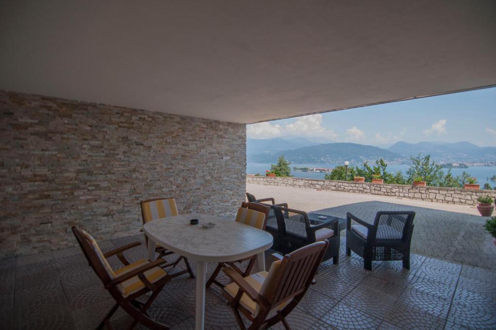 um pátio com uma mesa e cadeiras e uma vista em Villa Maria em Stresa