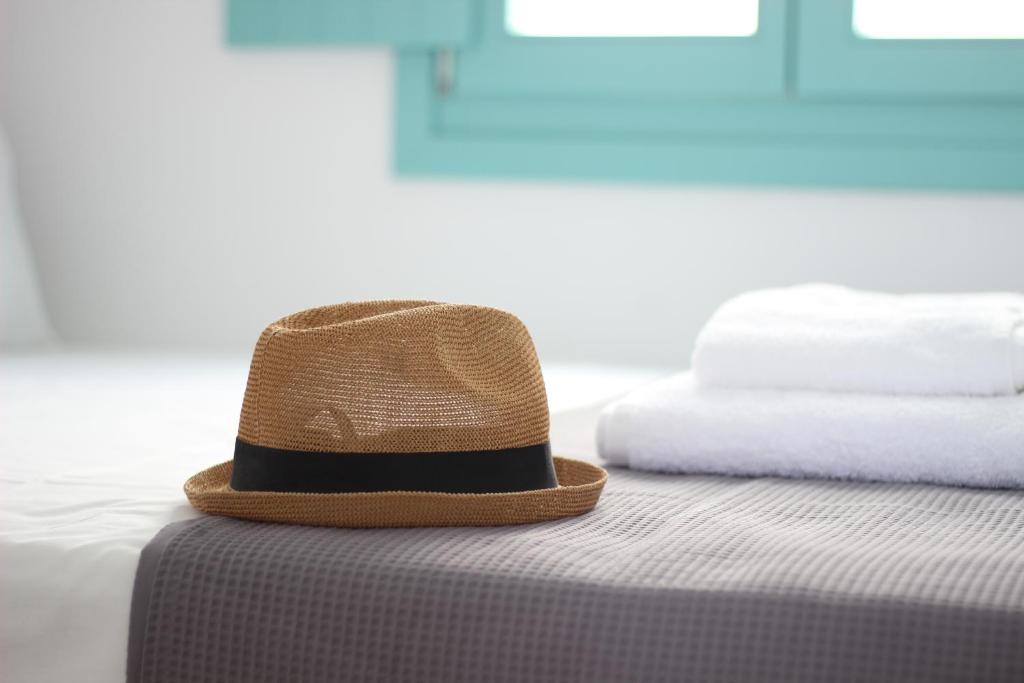 a hat sitting on top of a bed at Ploes Seaside Houses in Plaka