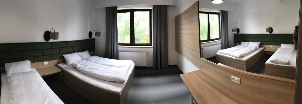 Habitación con 2 camas y 2 espejos. en Lesna Perla Hostel de lux, en Marklowice