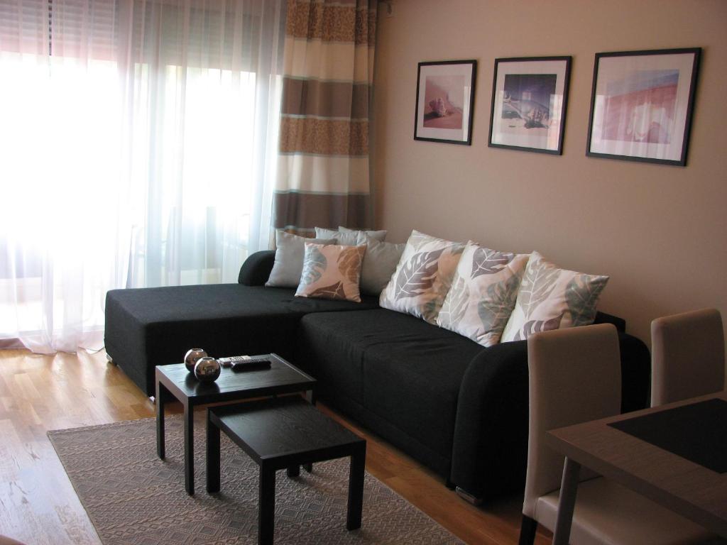 a living room with a black couch and a table at Apartment B&S in Budva