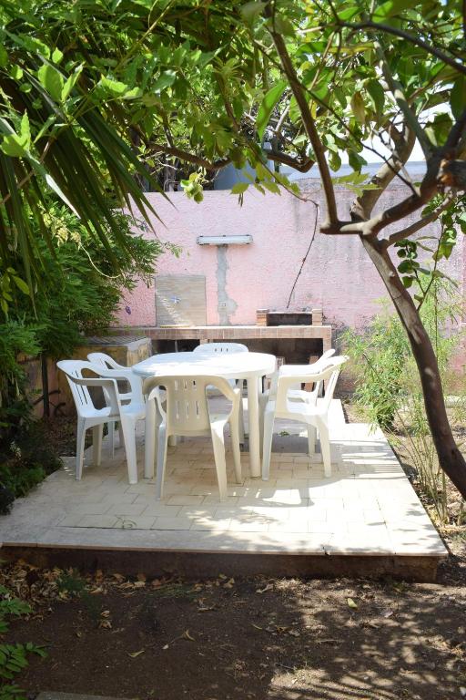 a white table and chairs sitting under a tree at Stefy Home in Catania
