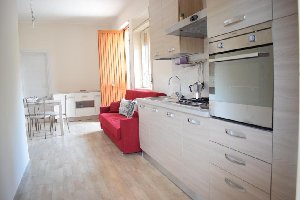a kitchen with a red couch and a red chair at Stefy Home in Catania