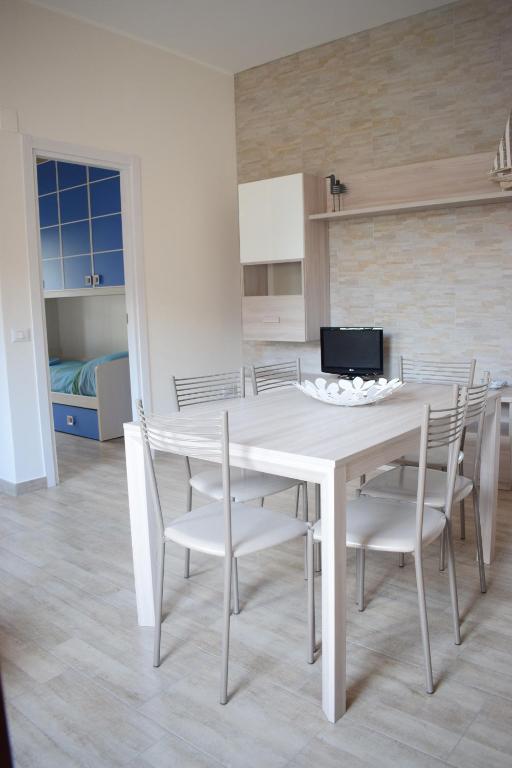 a white dining room with a white table and chairs at Stefy Home in Catania