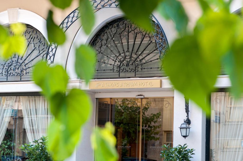 una entrada a un edificio con una puerta de hierro forjado en Athens Atrium Hotel & Jacuzzi Suites en Athens