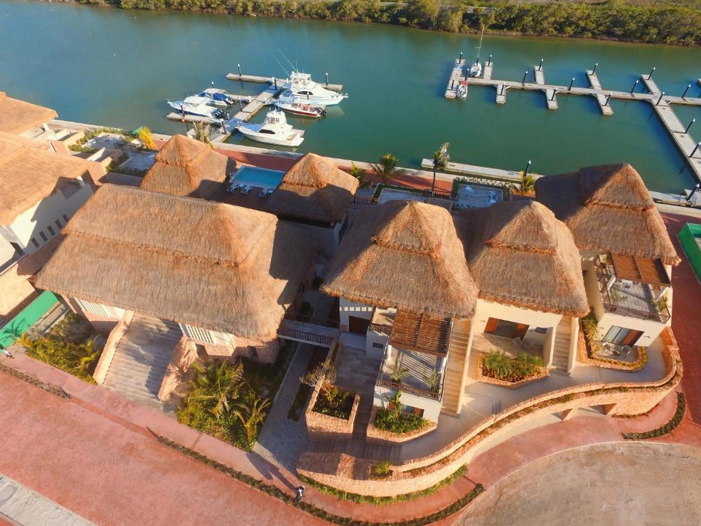 una vista aérea de una casa con techos de paja y un puerto en Villas Grand Marina Kinuh, en Telchac Puerto