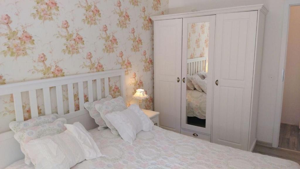 une chambre avec un lit blanc et un miroir dans l'établissement Romantic Style Apartment Berlin, à Berlin