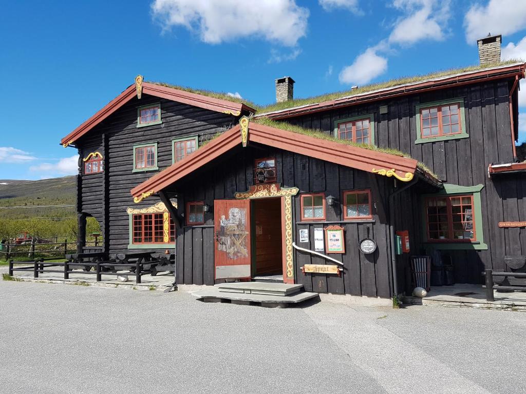 a large wooden building with a sign on it at Dovregubbens Hall in Vålåsjø