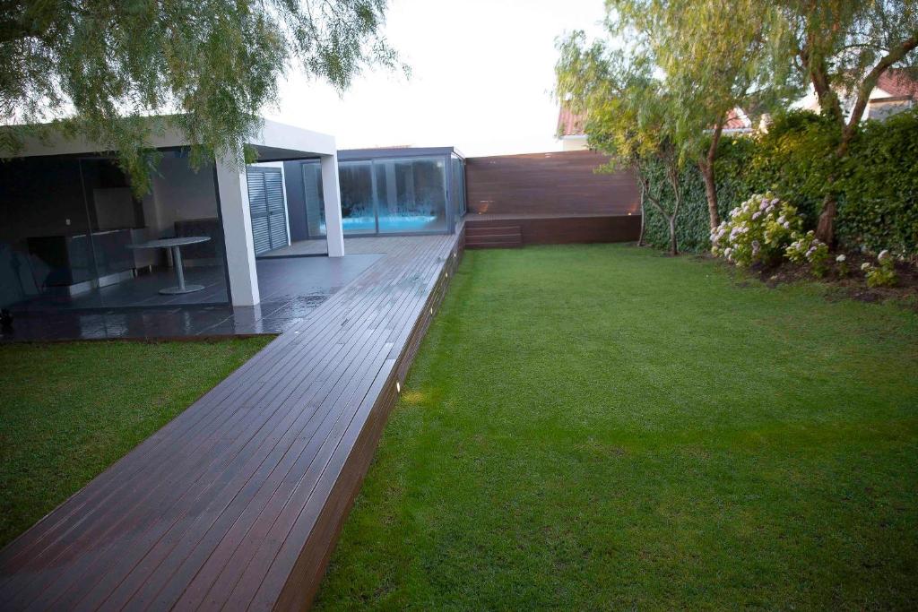 a wooden bench in the yard of a house at Apartment with Garden and Pool in Estoril