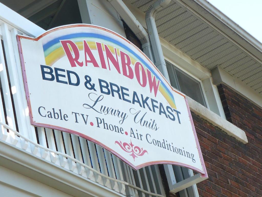 Rainbow Bed & Breakfast في شلالات نياجارا: وجود سرير قزاز وإشارة الإفطار على المبنى