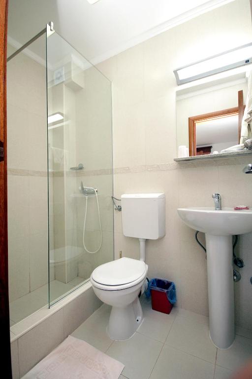 a bathroom with a toilet and a shower and a sink at Apartmani More in Sveti Stefan