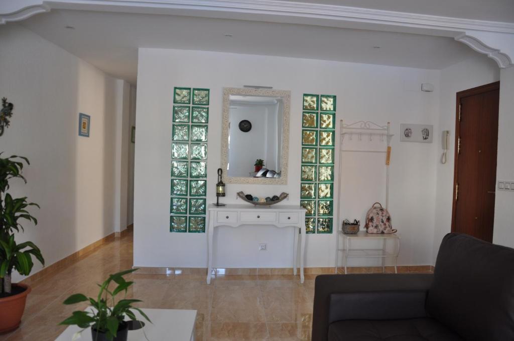 sala de estar con sofá y espejo en Alenia Apartments, en Alicante