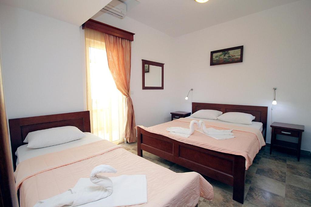 two beds in a room with swans on them at Apartmani More in Sveti Stefan