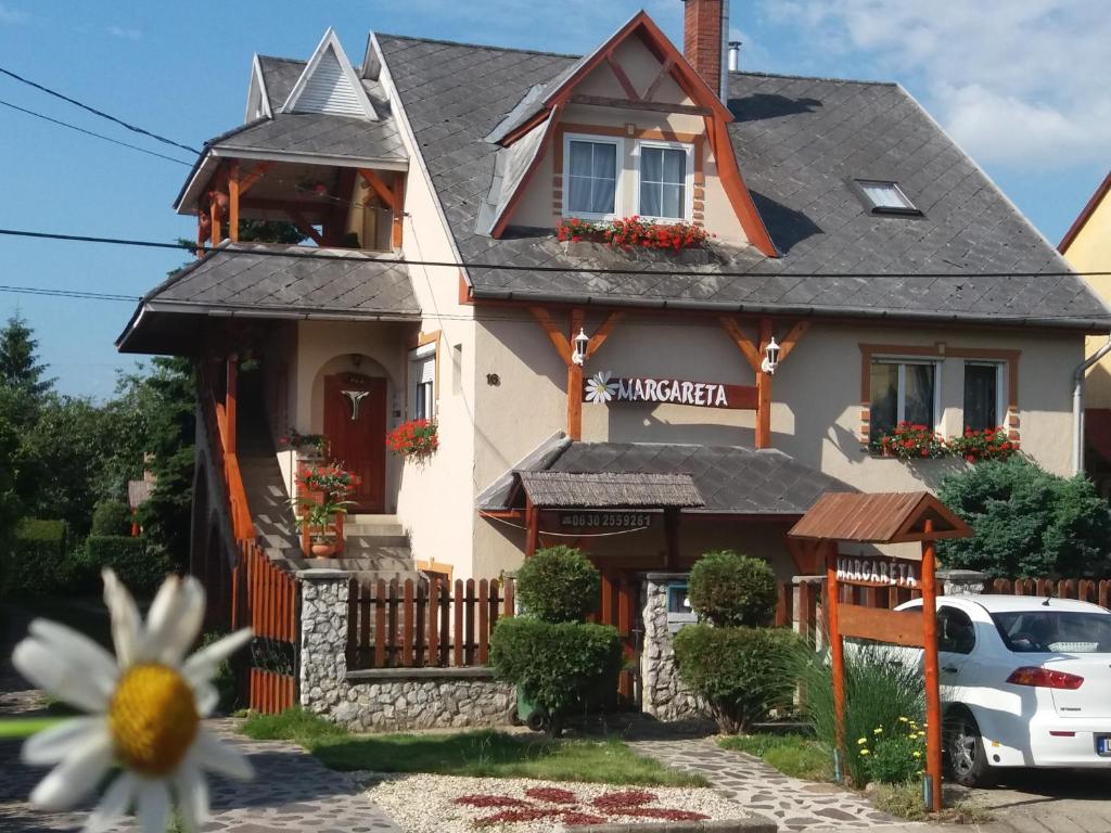 a house with a flower in front of it at Margaréta Panzió in Sárospatak