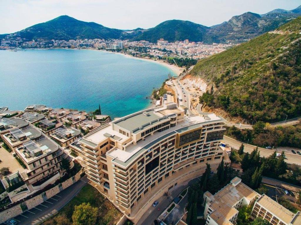 un gran edificio junto a una masa de agua en Harmonia Budva, en Budva