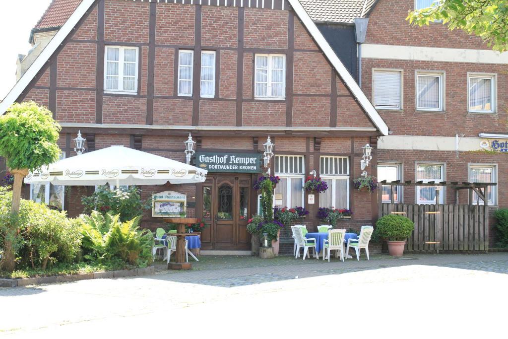 a building with tables and chairs in front of it at Hotel Kemper in Havixbeck