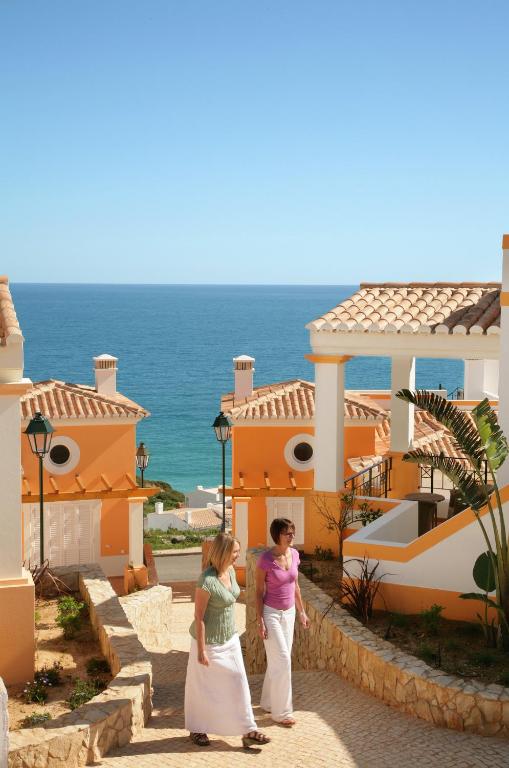 two people standing in front of a building at The View – Santo António Villas, Golf & Spa in Salema