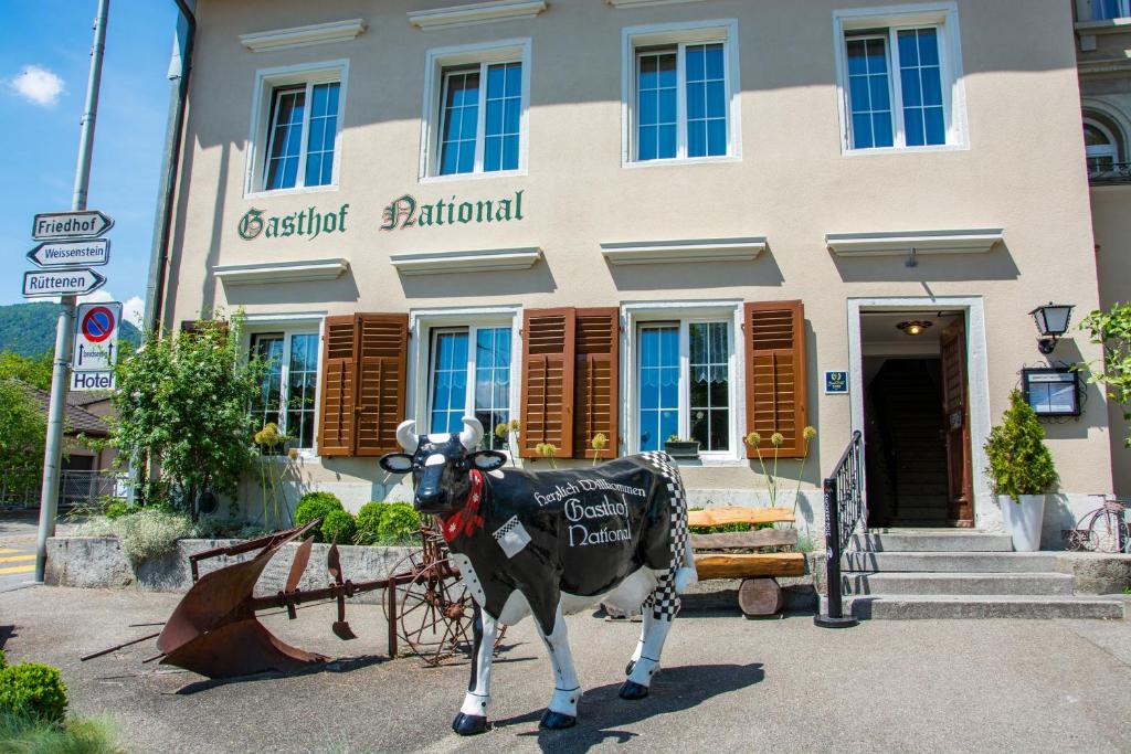 une statue d'une vache devant un bâtiment dans l'établissement Gasthof National, à Langendorf