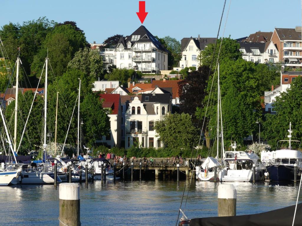 un grupo de barcos atracados en un puerto deportivo con casas en Stadtvilla mit Hafenpanorama en Flensburg